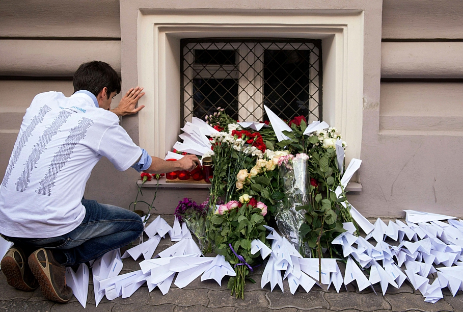 Мужчина ставит свечи у посольства Нидерландов в Москве в память о погибших в авиакатастрофе