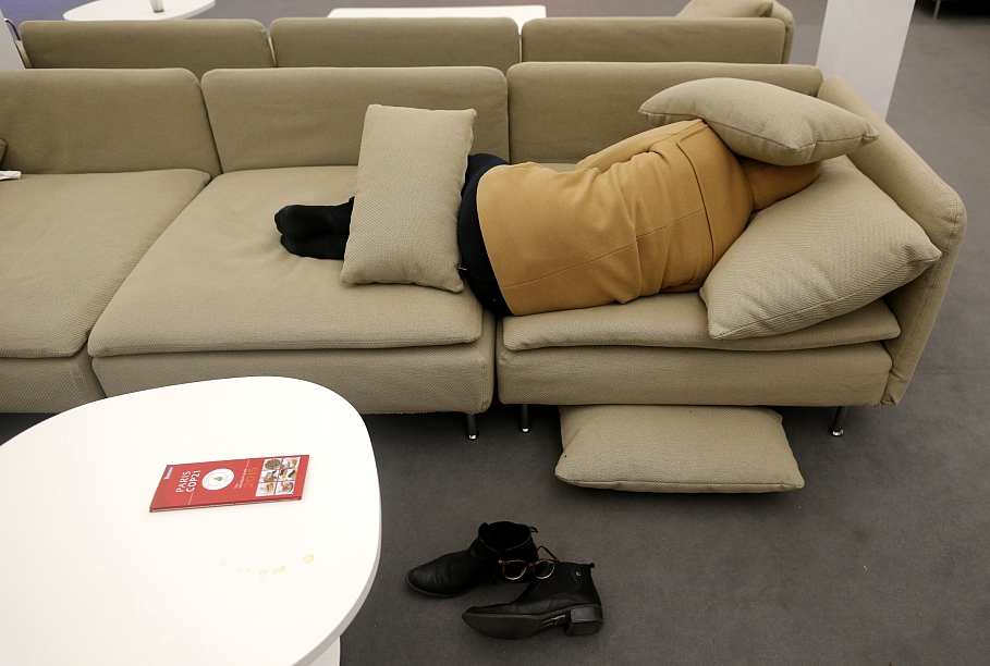 Pārguris klimata konferences dalībnieks guļ uz dīvāna