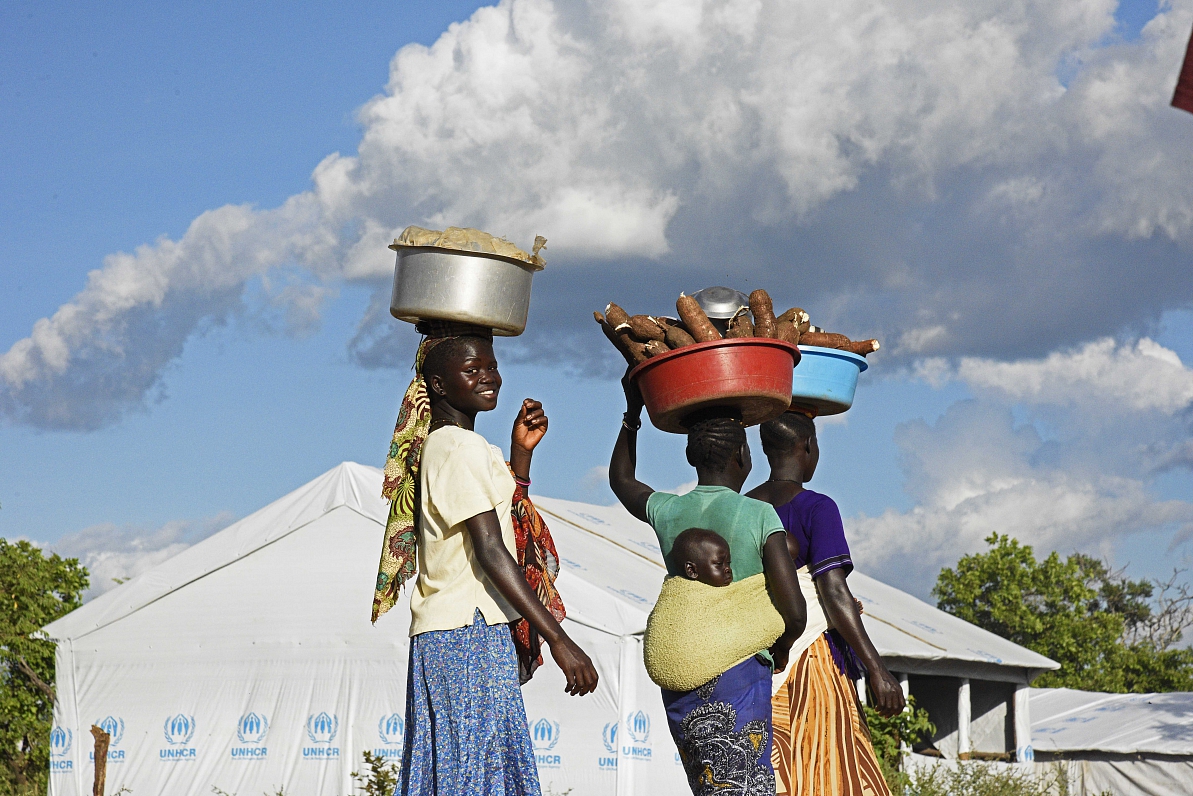 South Sudanese refugee women carry cassava on their heads at Bidibidi zone 2 settlement centre in No...