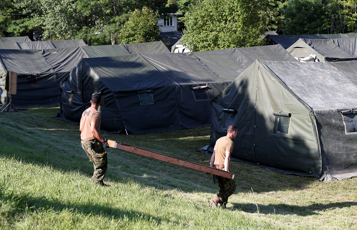 Kanādas karavīri pie teltīm, kur gaidīti patvēruma meklētāji