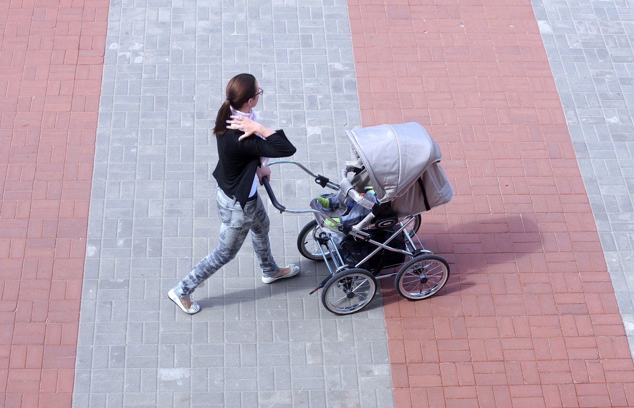 Sieviete ar bērna ratiņiem.