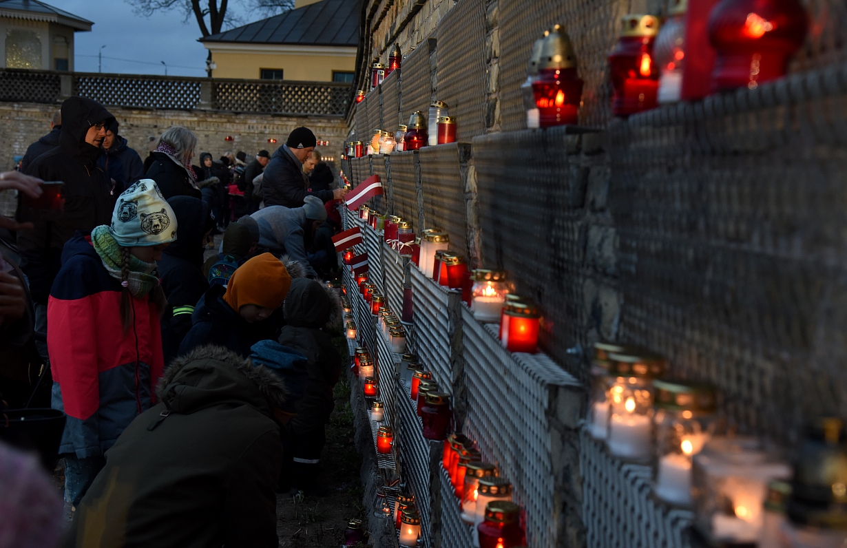 Par godu Lāčplēša dienai, cilvēki noliek svecītes pie Rīgas pils mūra 11.novembra krastmalā.