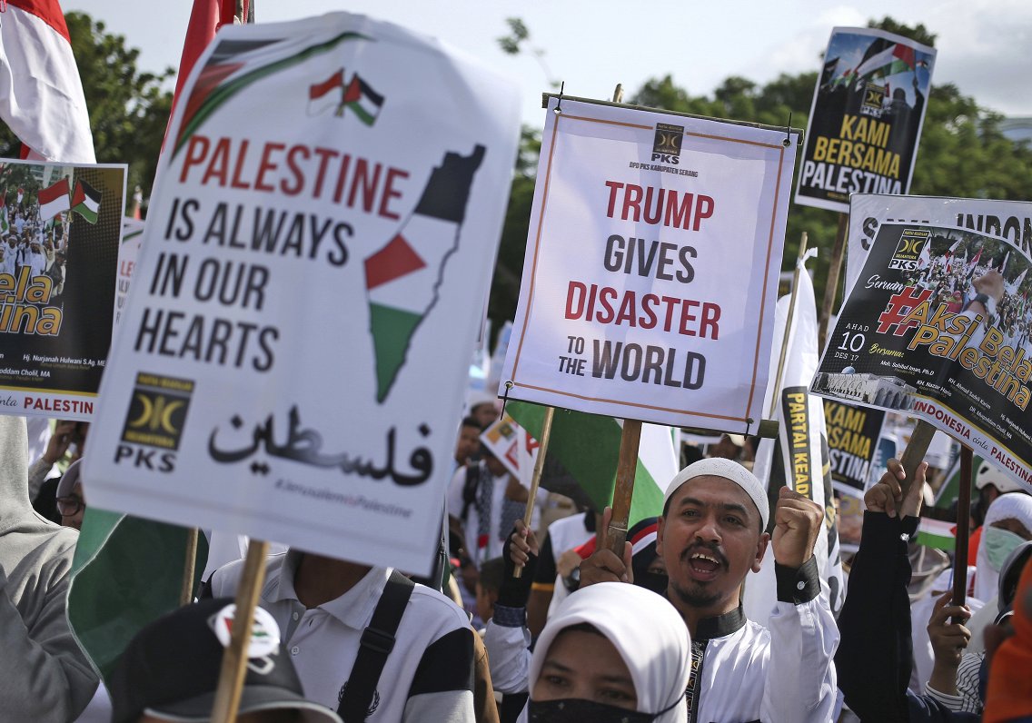 Muslims hold posters during a rally against President Donald Trump's decision to recognize Jerusalem...