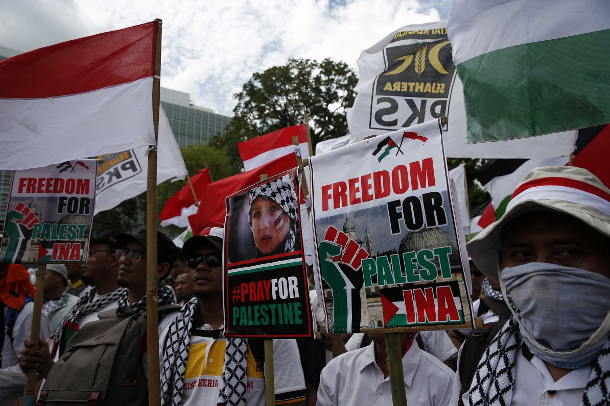 epa06380436 Indonesian Muslim activists hold pro-Palestinian placards during a protest against US Pr...