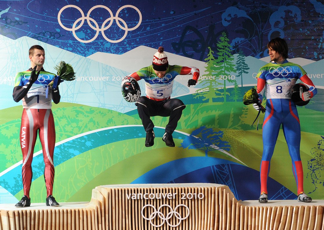 Martins Dukurs (pa kreisi) uz Vankūveras olimpiskā pjedestāla