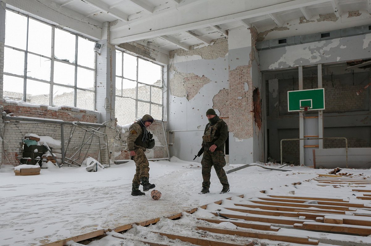 Ukrainas karavīri spārda bumbu izpstītā ēkā Marjinkas ciematiņā