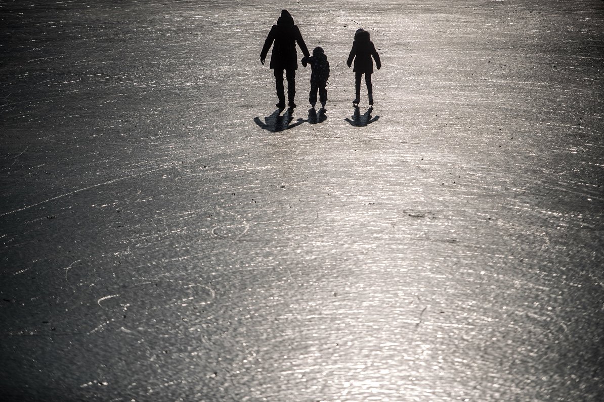 Cilvēki iet pa ledu Prāgā, Čehijā