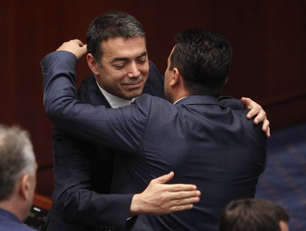 Maķedonijas premjerministrs Zorans Zaevs un ārlietu ministrs Nikola Dimitrovs apskaujas pēc parlamen...