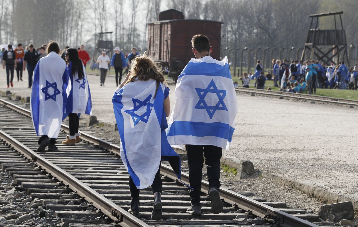 Cilvēki ar Izraēlas karogiem Aušvicas-Birkenavas nometnē