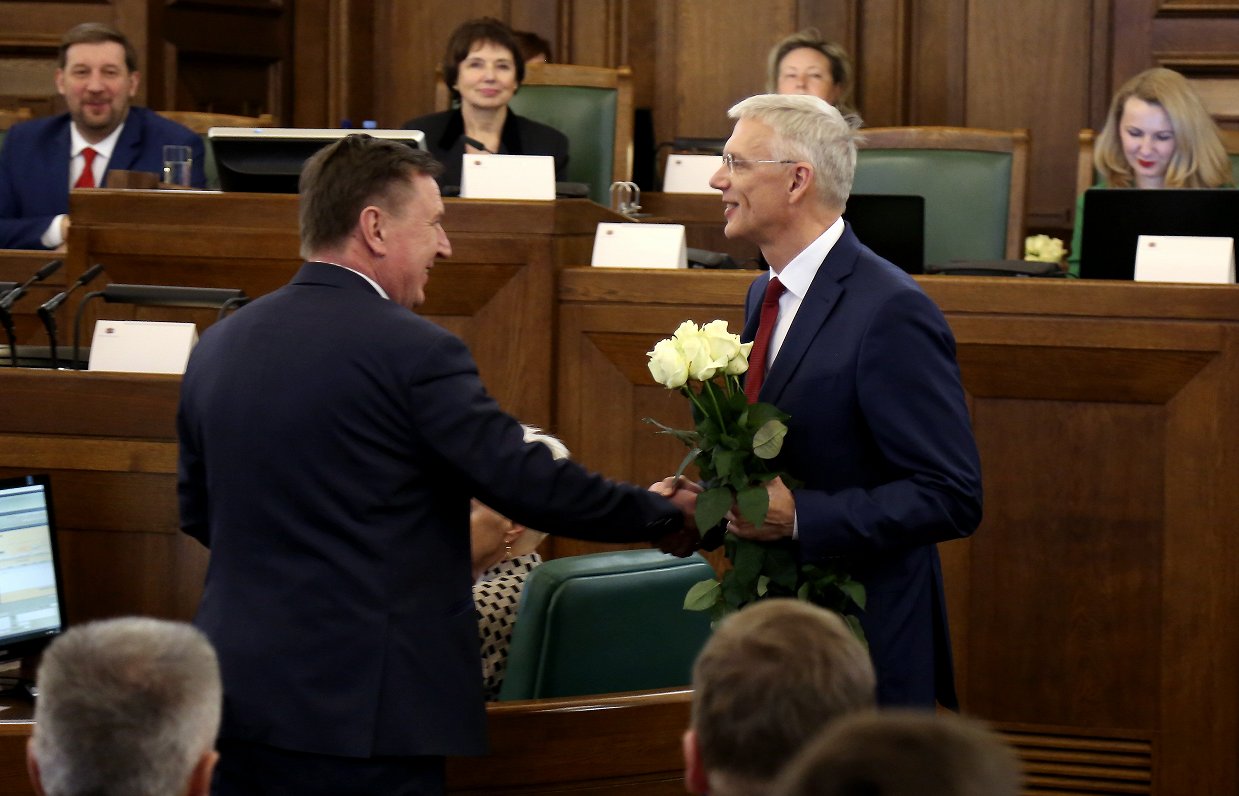 Jaunievēlētais Ministru prezidents Krišjānis Kariņš (no labās) saņem ziedus no bijušā Ministru prezi...