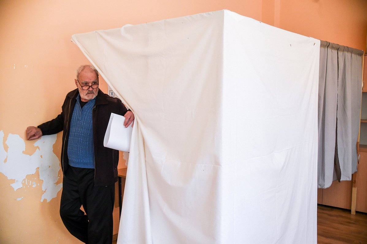 Kāds vīrietis iznāk no balsošanas būdiņas Bulgārijas galvaspilsētā Sofijā