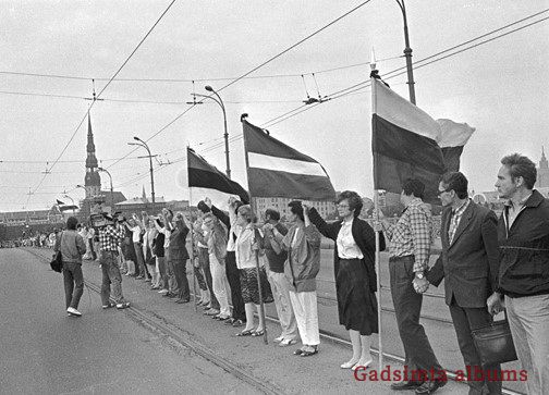 Marta Zepa (ceturtā no labās puses) ar vīru un darba biedriem uz Akmens tilta ar Baltijas karogiem