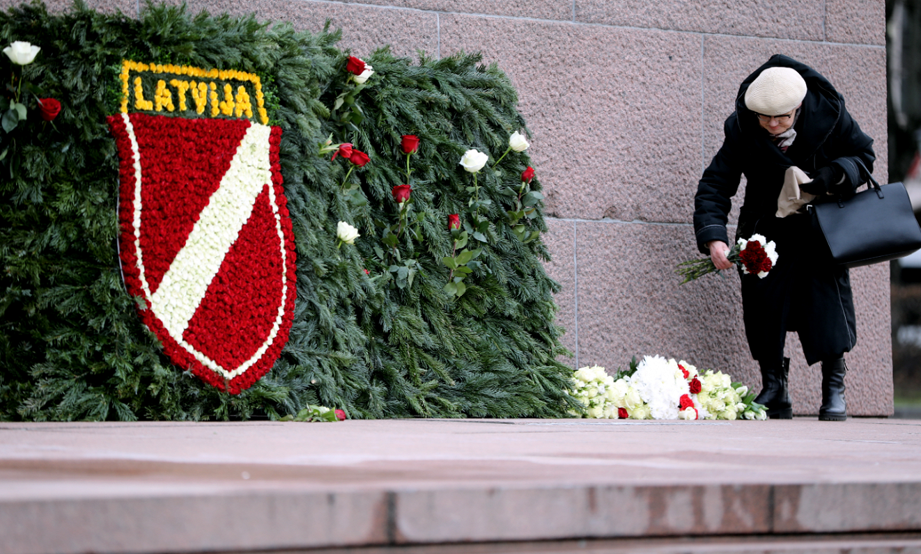 Sieviete noliek ziedus pie Brīvības pieminekļa Leģionāru atceres dienā.