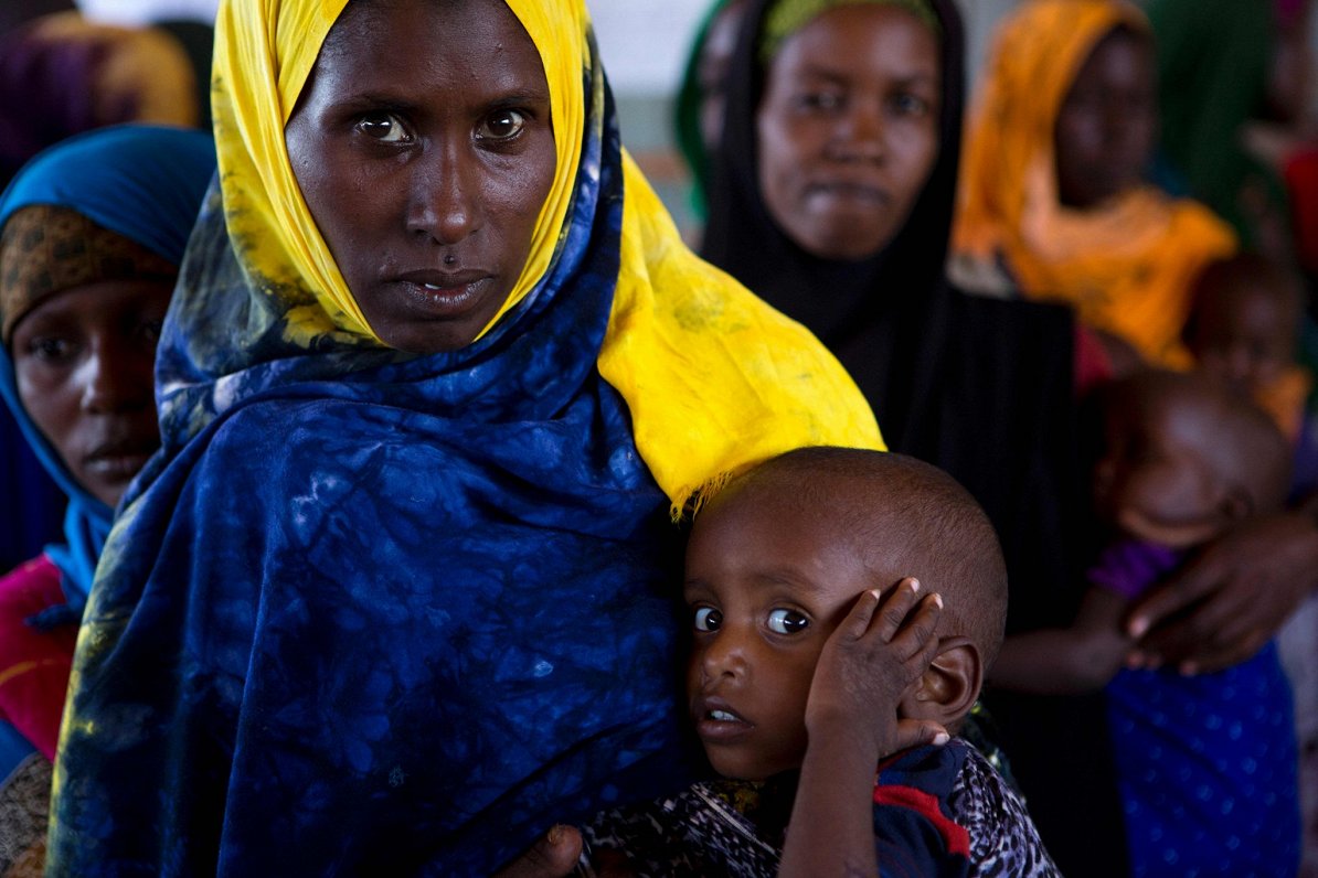 Sieviete no Somālijas gaida, kad viņas bērnu izmeklēs veselības centrā (2017. gads)