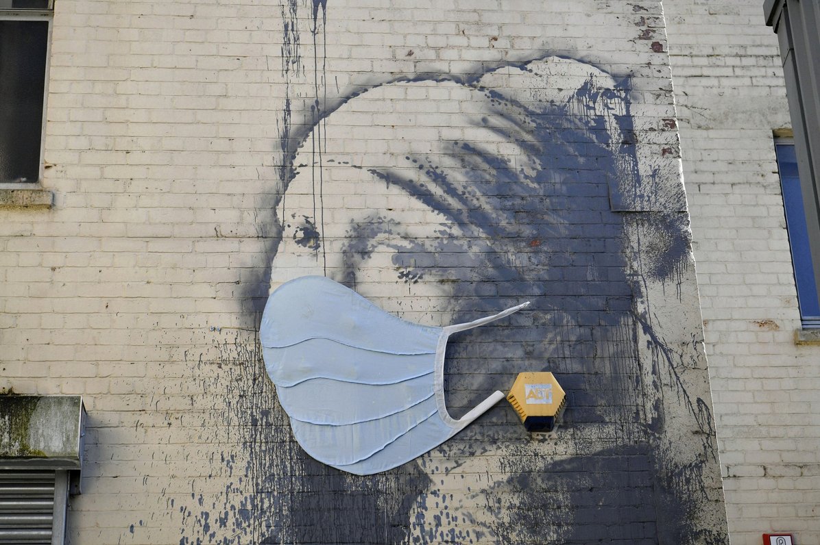 Benksija grafiti Lielbritānijā pievienota sekas maska, reaģējot uz Covid-19 pandēmiju, 22.04.2020