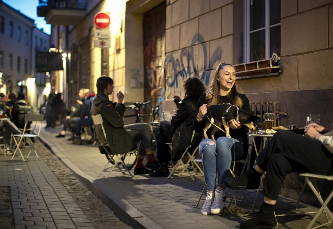 Jaunieši  kafejnīcā Viļņas vecpilsētā, kur ļauts bez maksas izvietot āra galdus. 01.05.2020.