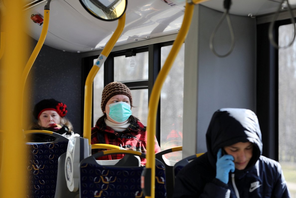Cilvēki sabiedriskajā transportā izmanto maskas.
