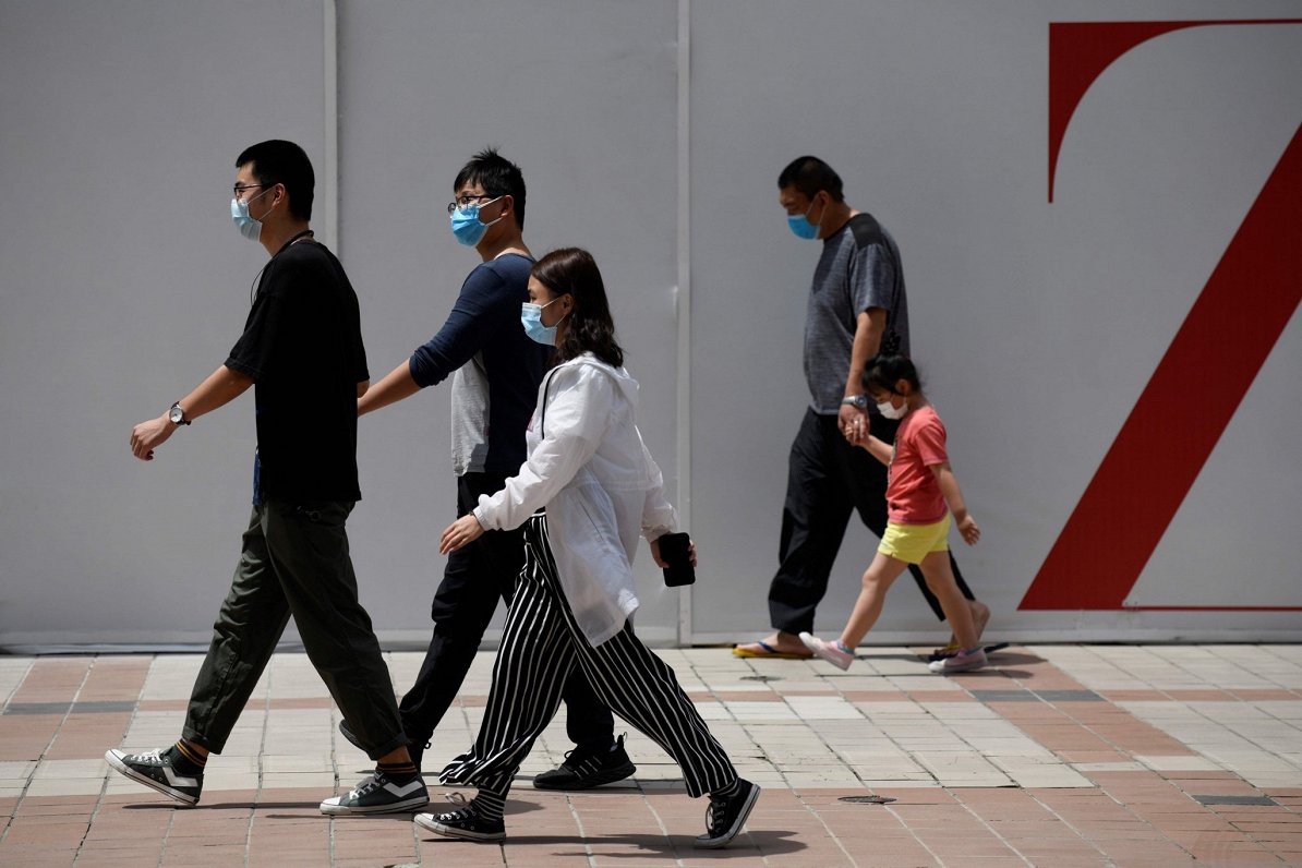 Cilvēki Pekinā ar sejas maskām aizsardzībai pret Covid-19 vīrusu. 2020. gada 20. maijs.