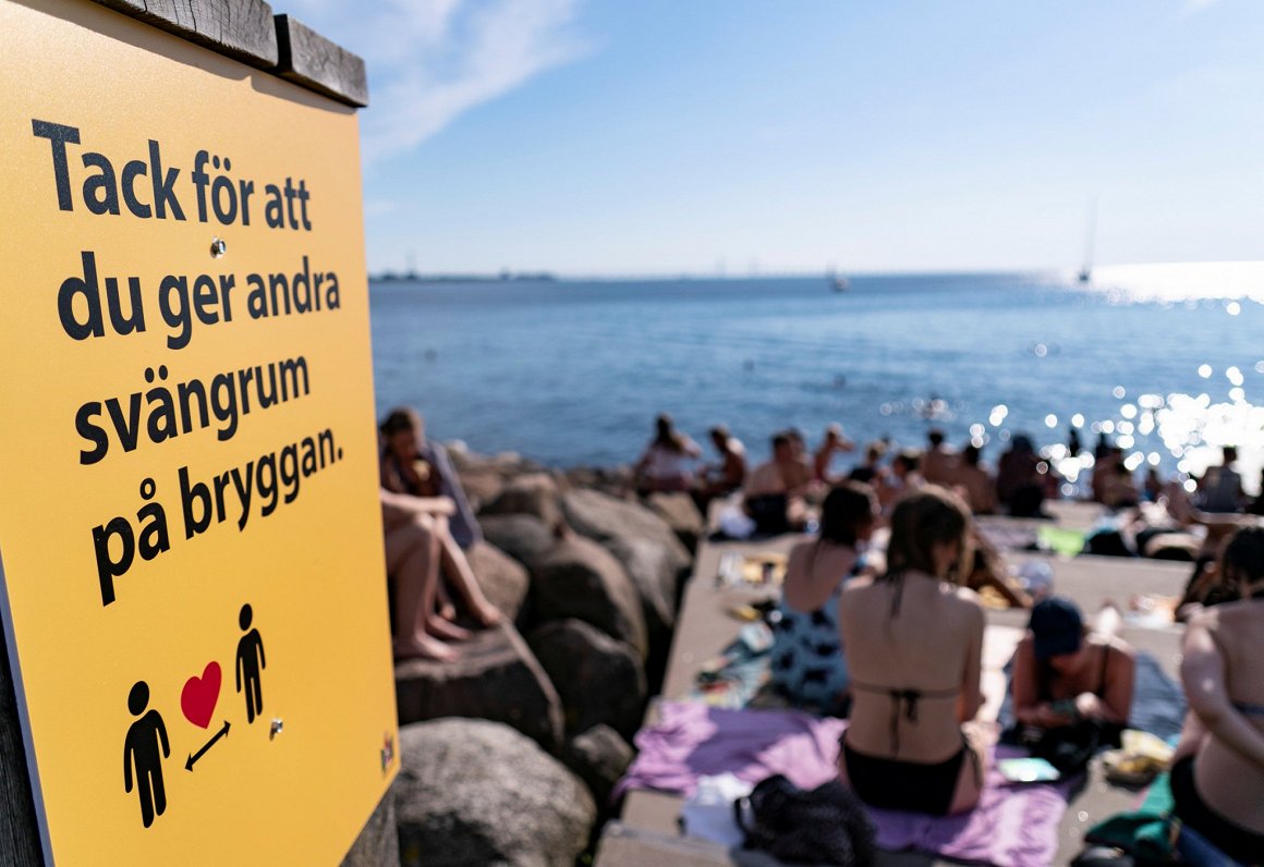 Informatīvā zīme Malmes pludmalē, kas aicina ievērot distanci. Zviedrija. 2020. gada 25. jūnijs.
