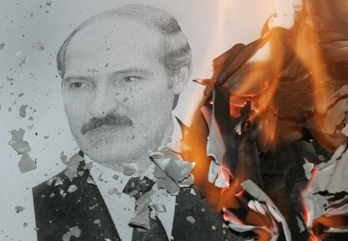 Opozīcijas protestētāji dedzina Aleksandra Lukašenko portretu.