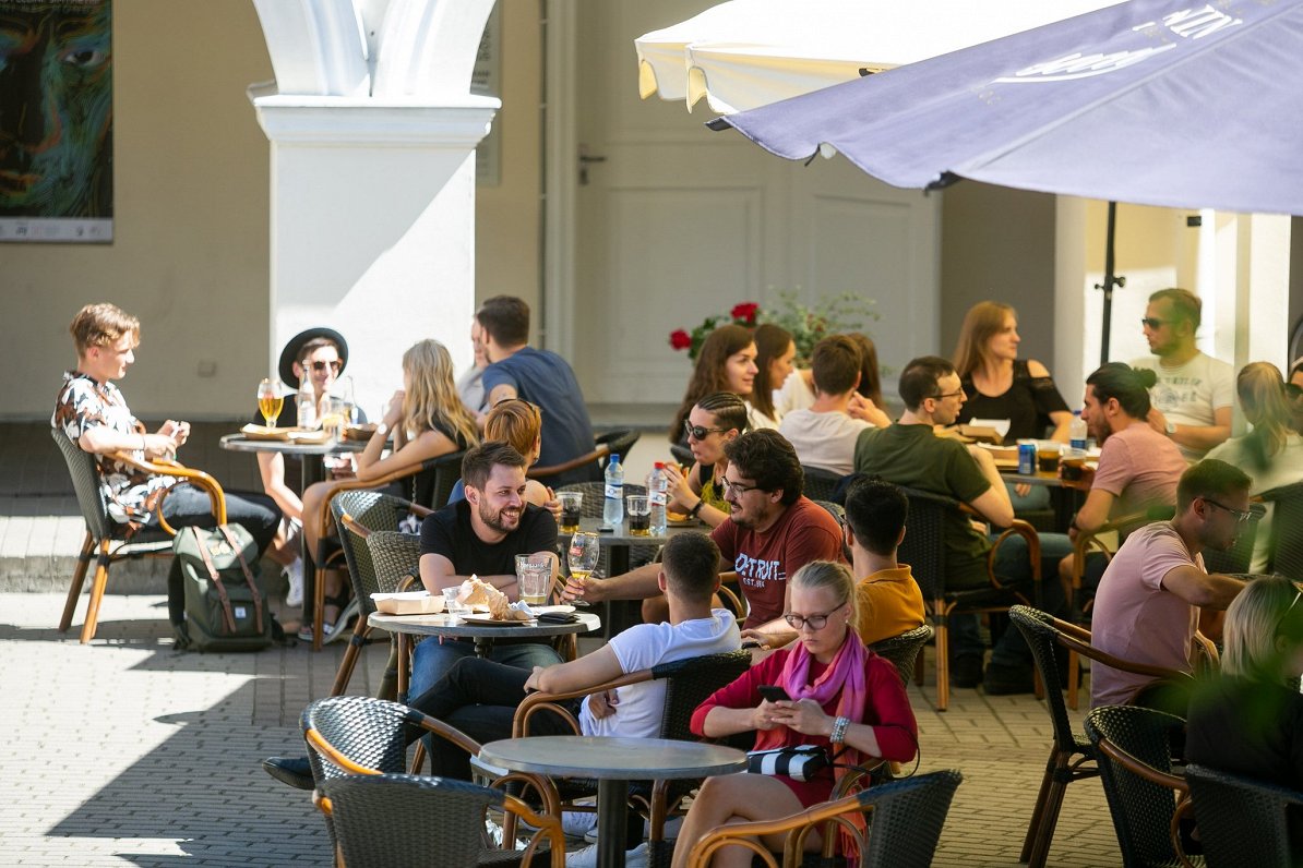 Cilvēki āra kafejnīcā Lietuvas pilsētā Viļņā. 2020. gada vasara.