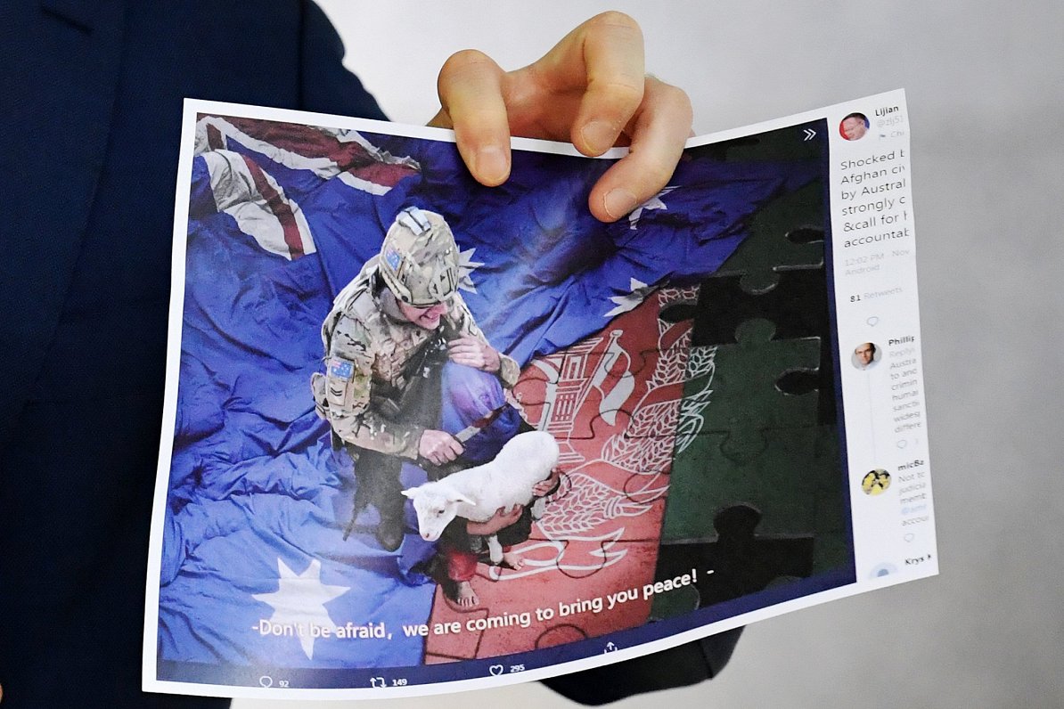 Ķīnas ārlietu ministrijas izplatīts viltus attēls ar Austrālijas karavīru, kurš tur nazi pie bērna r...