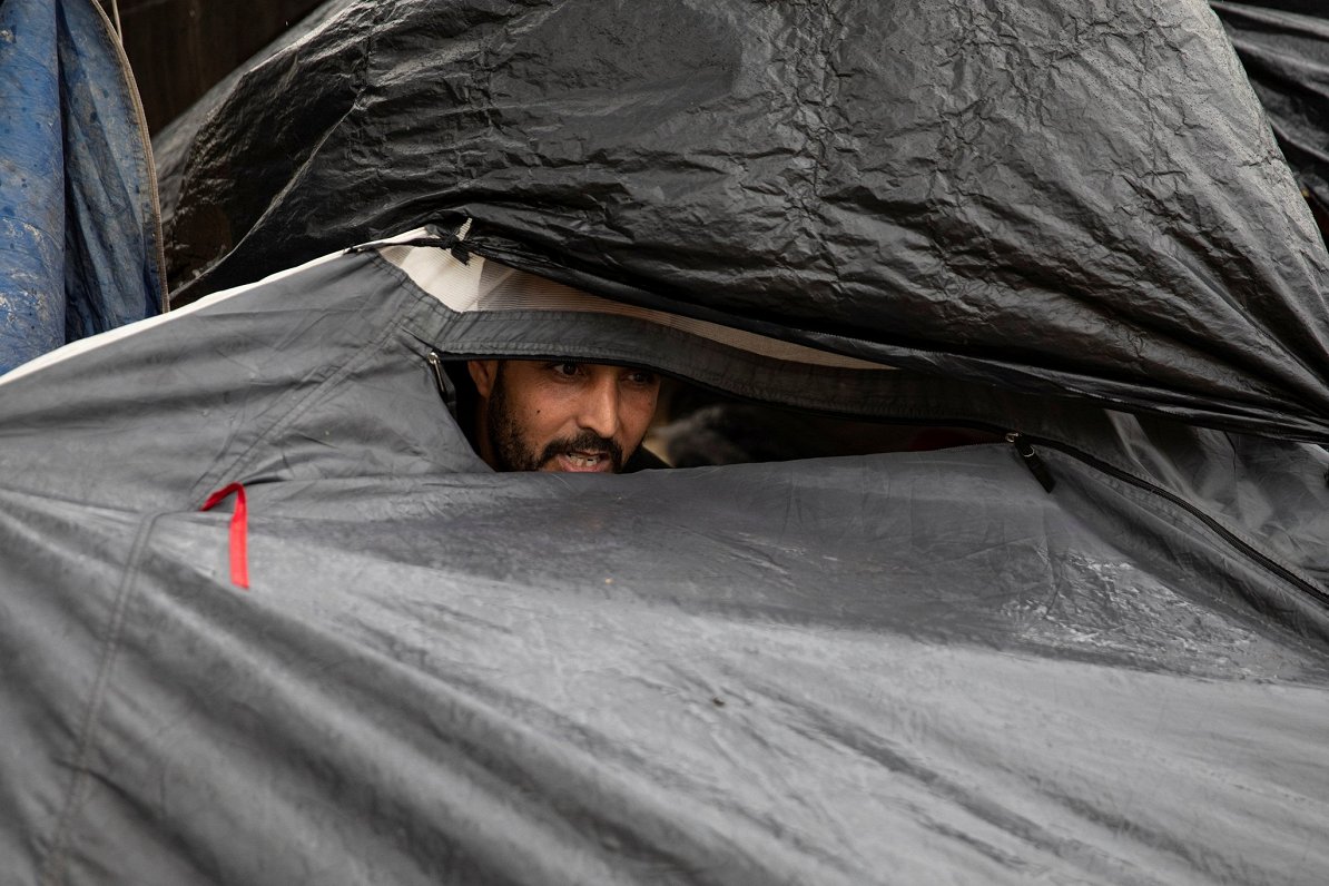 Cilvēks imigrantu nometnē pie Ungārijas un Serbijas robežas