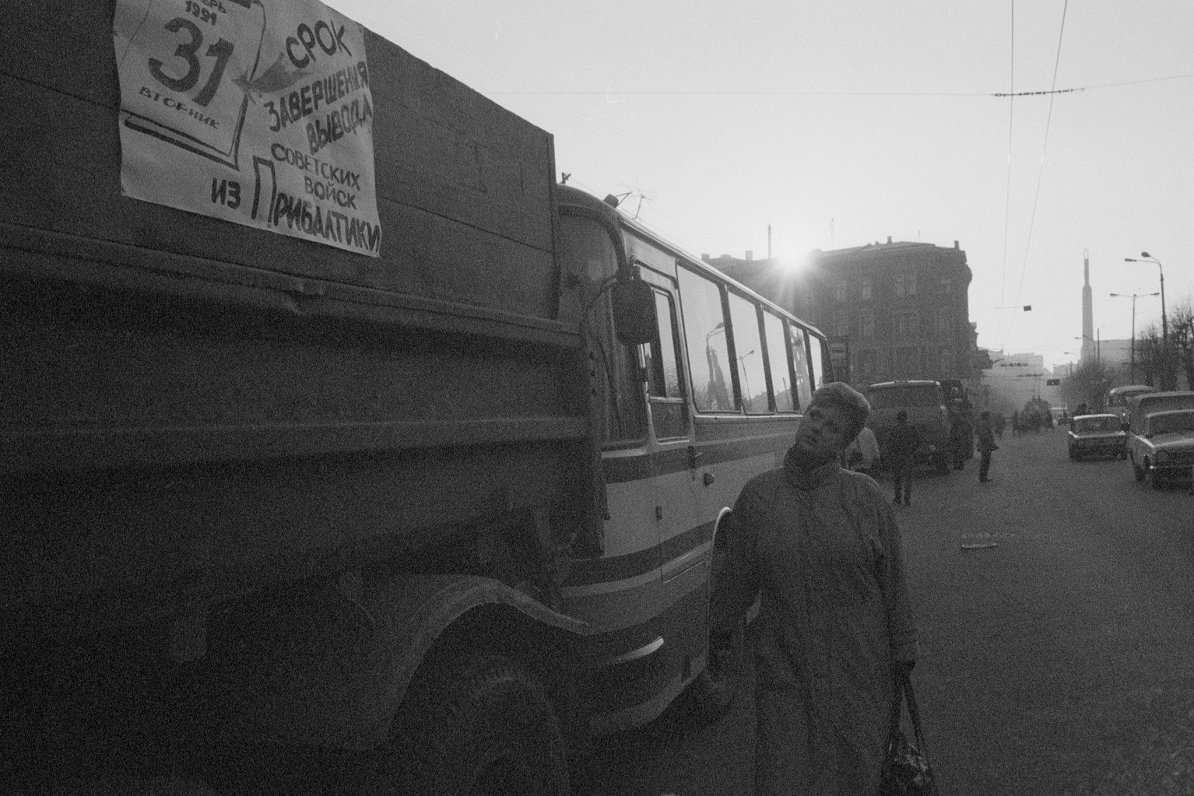18.01.1991. Sieviete vēro plakātu par PSRS karaspēka izvešanu uz auto pie Ministru padomes.