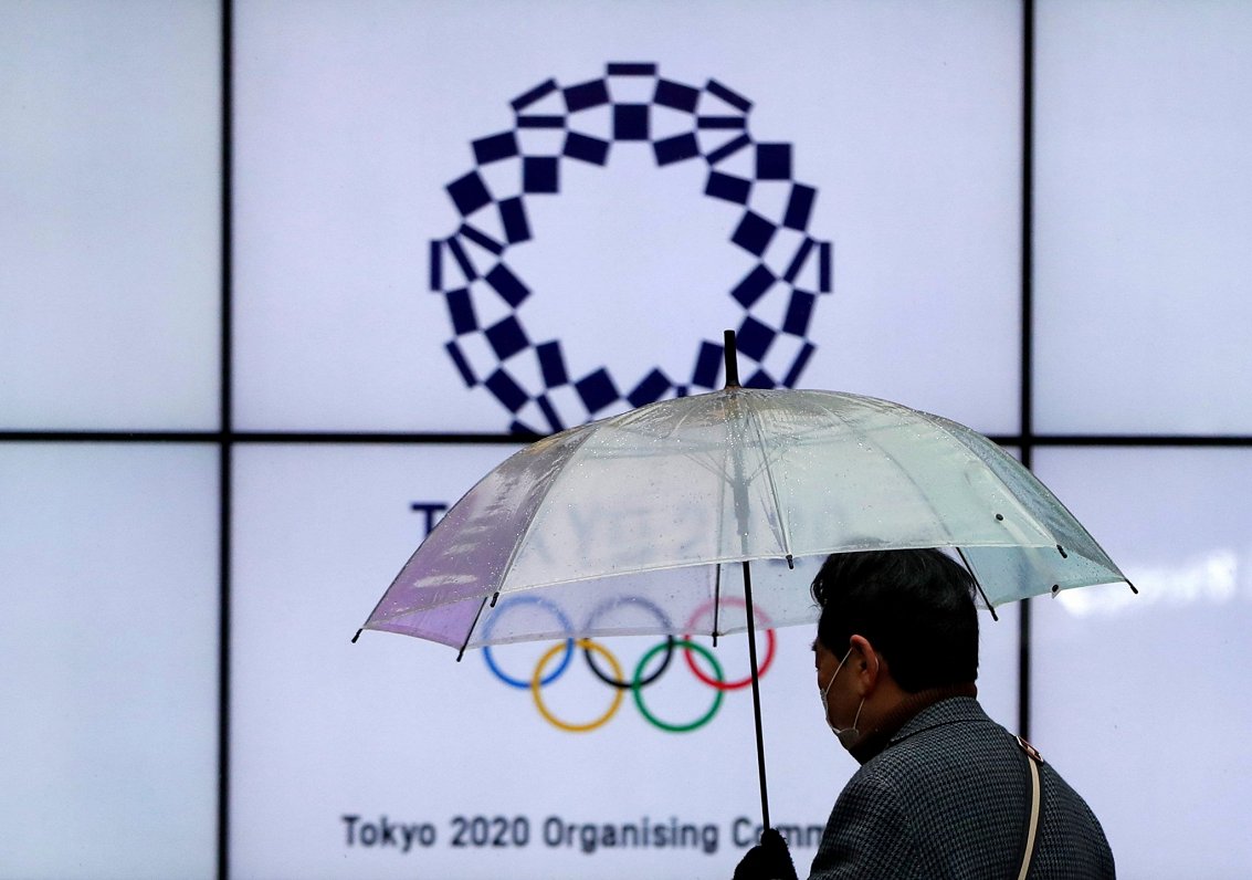 Vīrietis maskā pie Tokijas olimpisko spēļu logo Japānā (23.01.2021)
