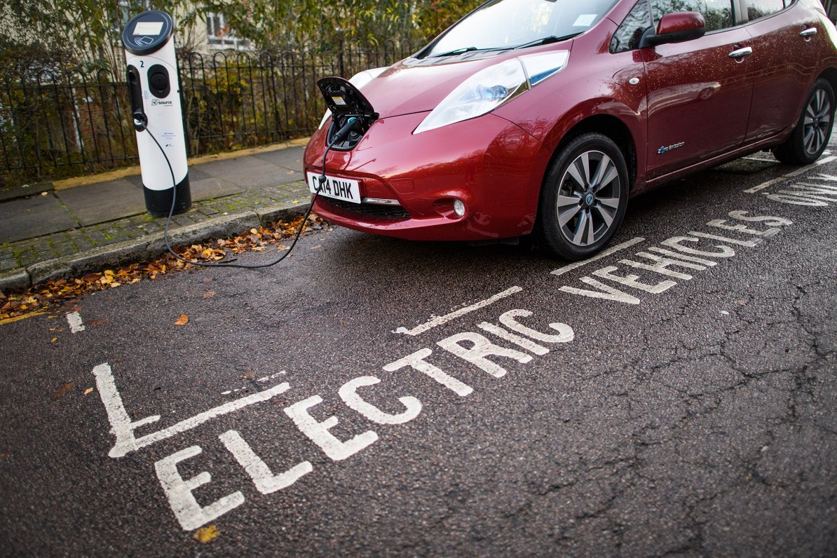 Pirmais plaša patēriņa elektroauto 2011. gada &quot;Nissan Leaf&quot; pie uzlādes stacijas Lielbritā...