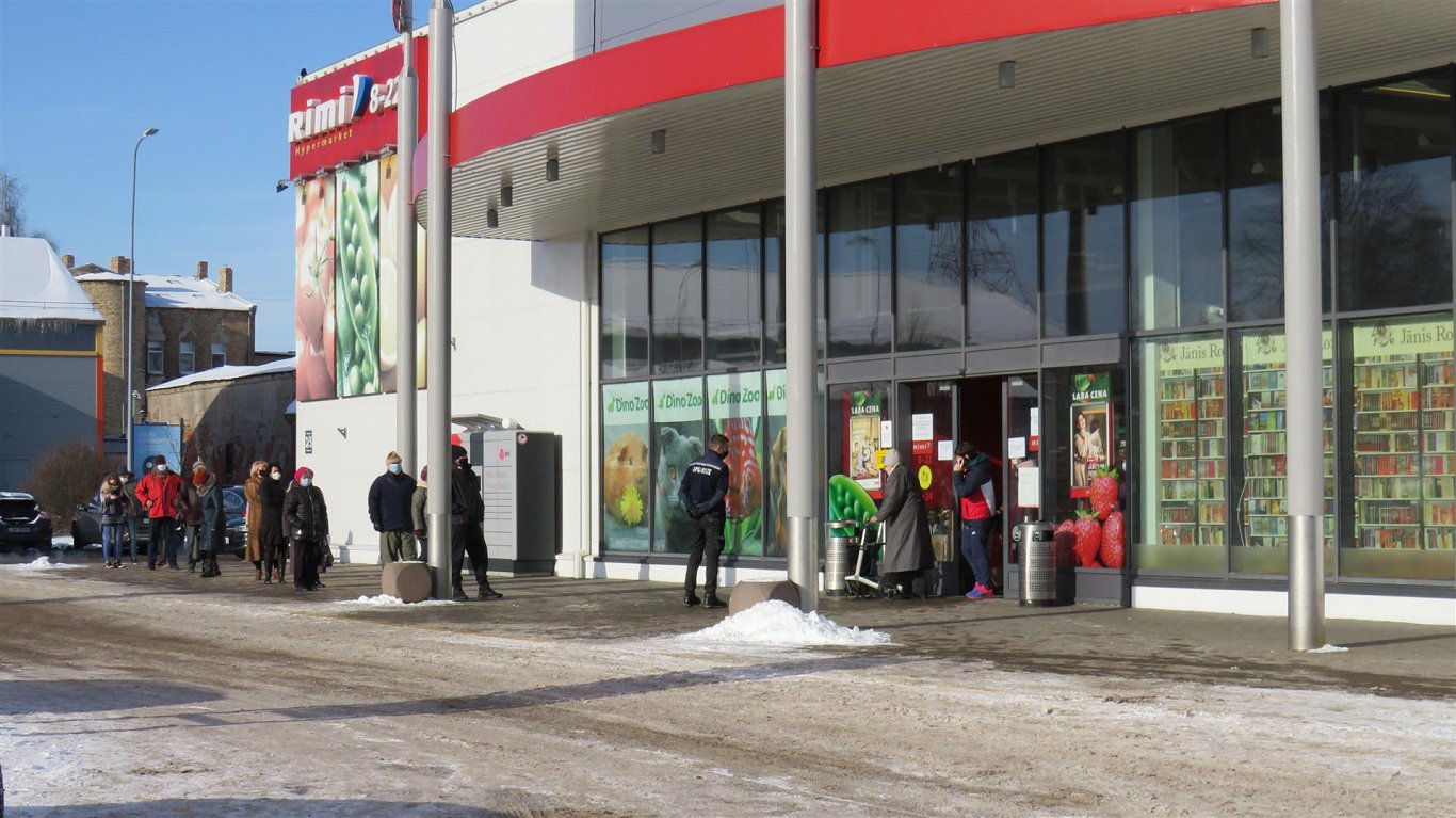 Покупатели ждут в очереди, чтобы зайти в торговый центр Rietumu в Лиепае, 8 февраля 2021 г.