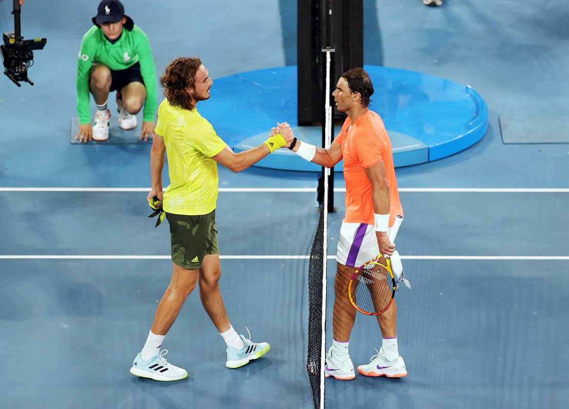 Stefans Cicips (pa kreisi) pēc uzvarētās spēles sarokojas ar Rafaelu Nadalu