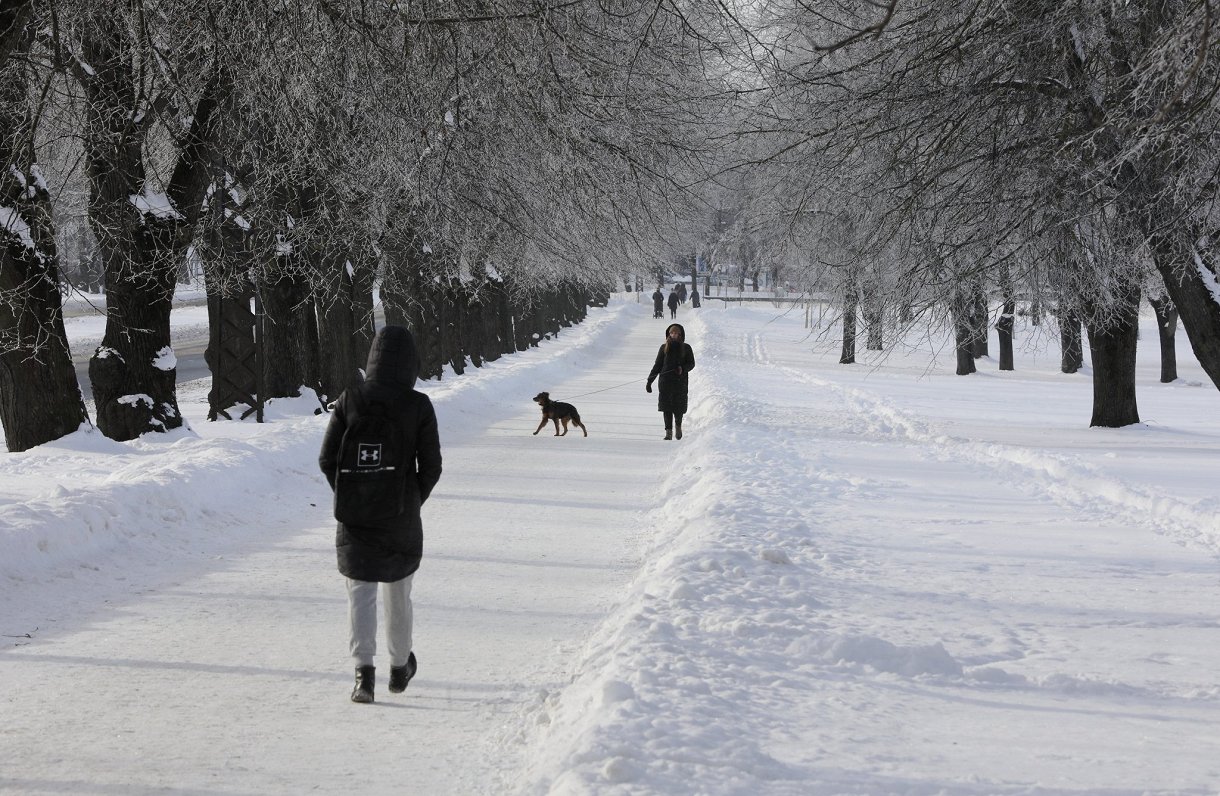Cilvēki pastaigājas Rīgas Uzvaras parkā
