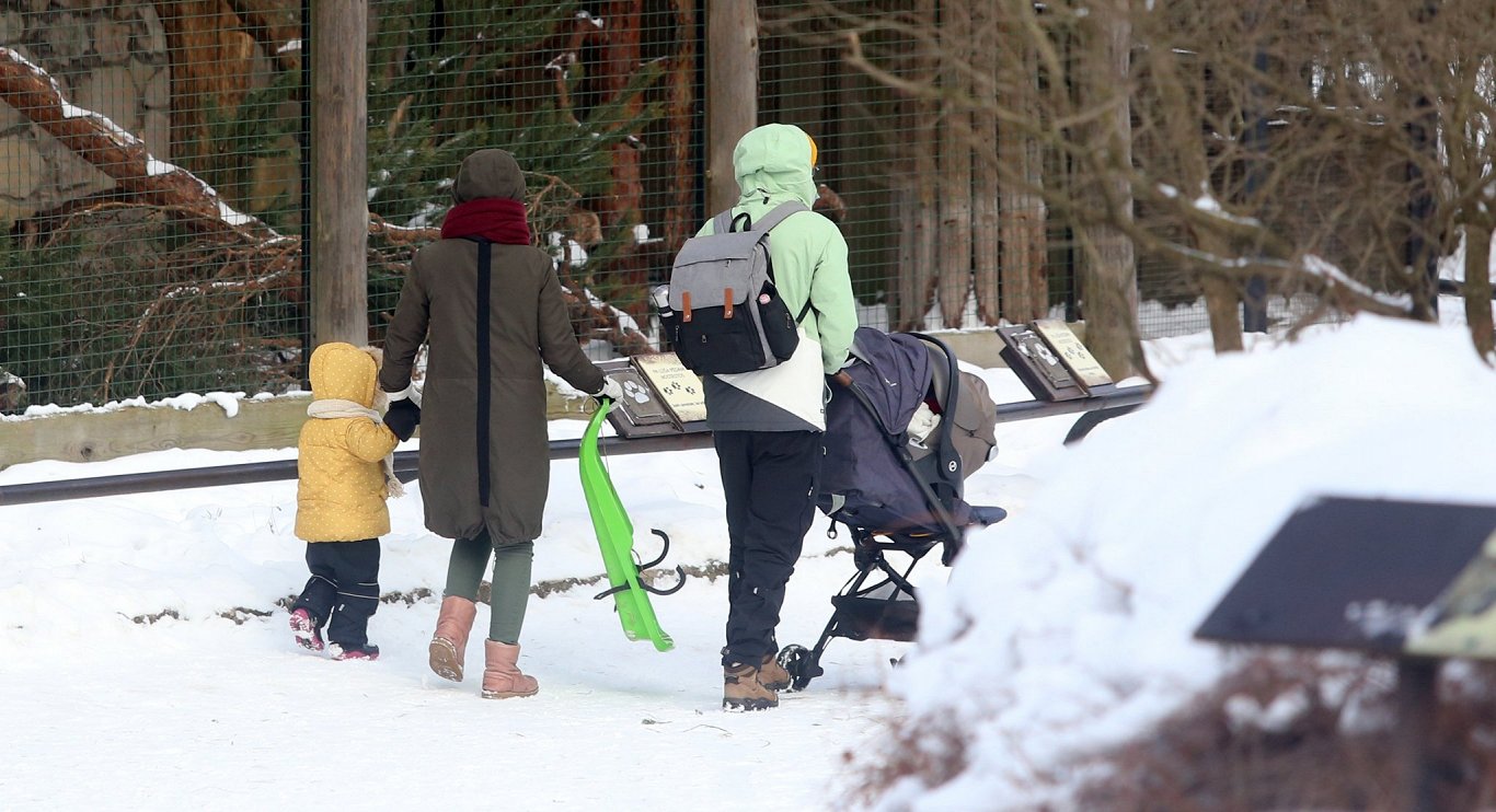 Ģimene ar bērniem ziemas pastaigā