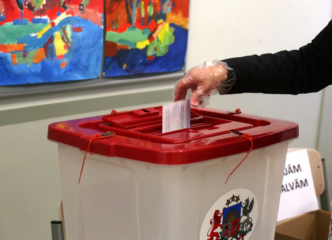 Vēlētājs met vēlēšanu biļeti balsojuma urnā. Attēls ilustratīvs.