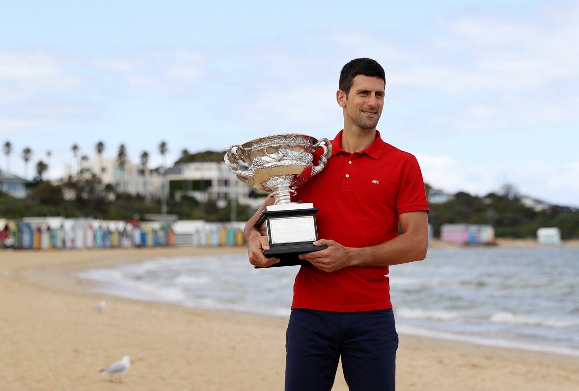 Novaks Džokovičs ar čempiona kausu 2021.gadā Melburnas pludmalē