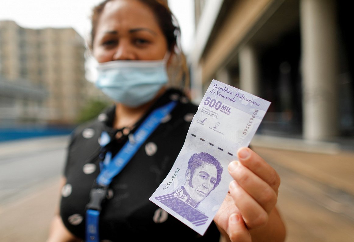 Venecuēlas iedzīvotāja ar 500 000 bolivaru banknoti. Tās vērtība ir ap 20 eirocentu
