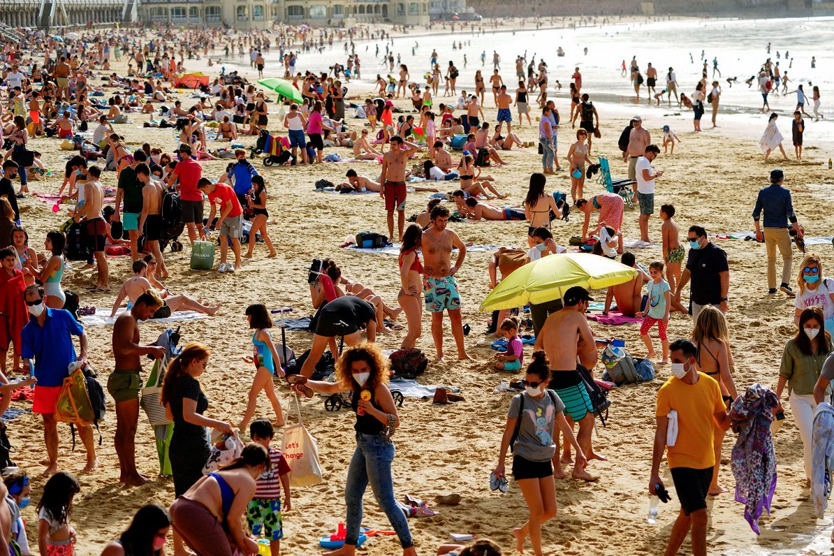 Spānijā cilvēki pulcējas pludmalēs, bet valdība pieprasa, lai viņi lietotu sejas masku