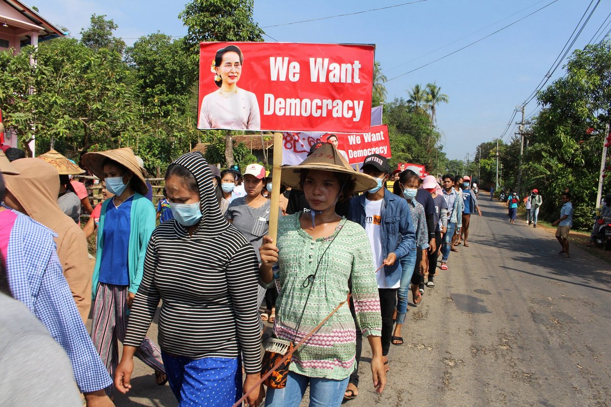 Mjanmas protestētāji ar plakātu &quot;Mēs gribam demokrātiju&quot;
