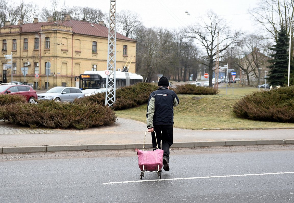 Vīrietis šķērso ielu Rīgā, Maskavas forštatē.
