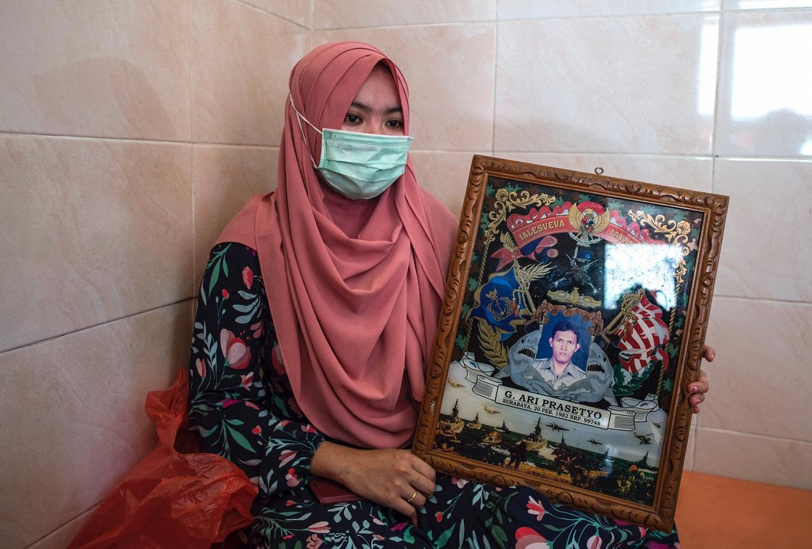 Indonēzijas iedzīvotāja Berda Asmara ar sava vīra attēlu. Domājams, ka visi 53 pazudušās zemūdenes a...