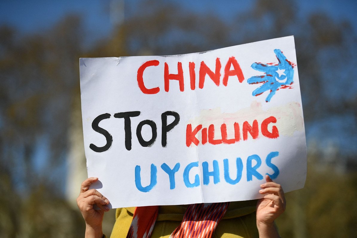 Plakāts ar saukli &quot;Ķīna, apturiet uiguru nogalināšanu&quot;