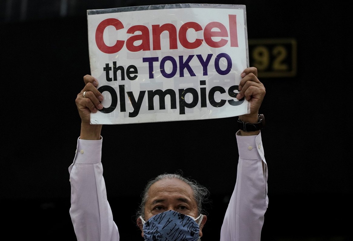 Protestētājs ar lozungu &quot;Atceliet Tokijas olimpiādi!&quot;
