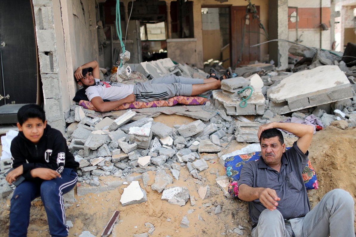 Palestīnieši atpūšas Izraēlas uzbrukumā bojātās mājas drupās
