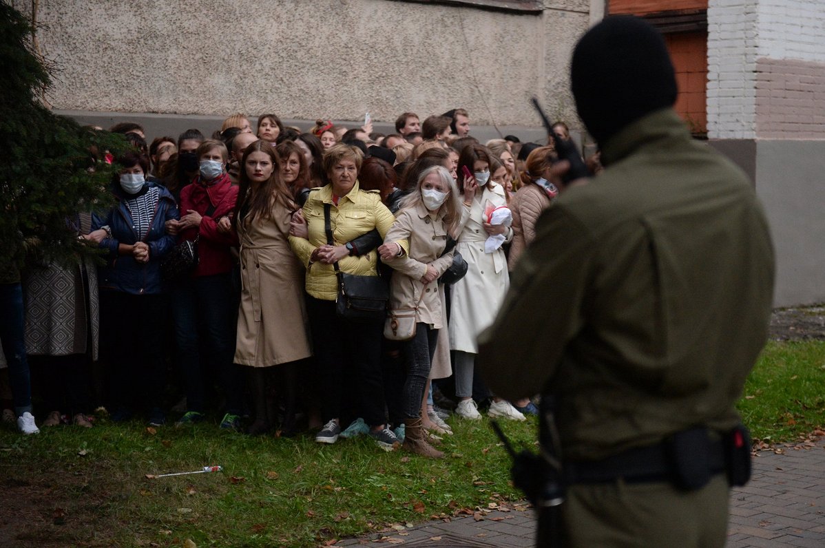 Baltkrievu sievietes sadevušās rokās, stājoties pretī &quot;omoniešiem&quot;