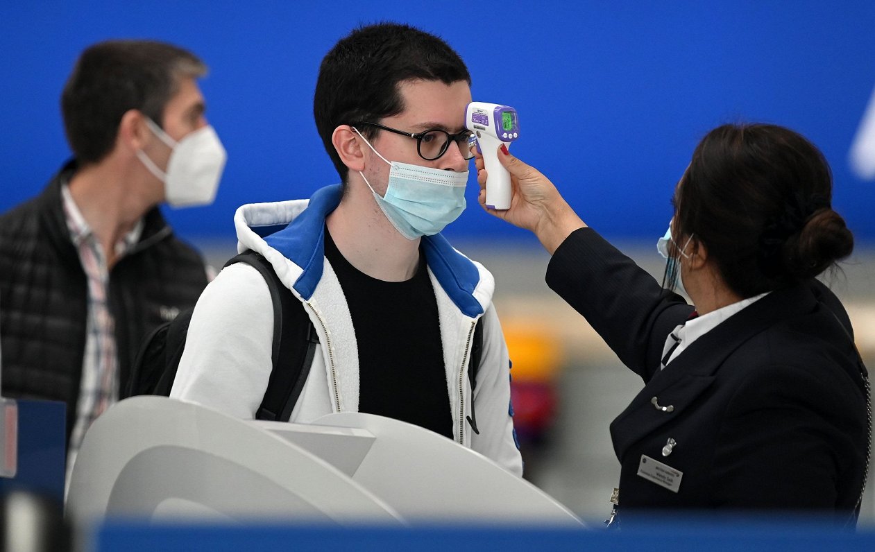 Hītrovas lidostā pasažierim tiek mērīta ķermeņa temperatūra