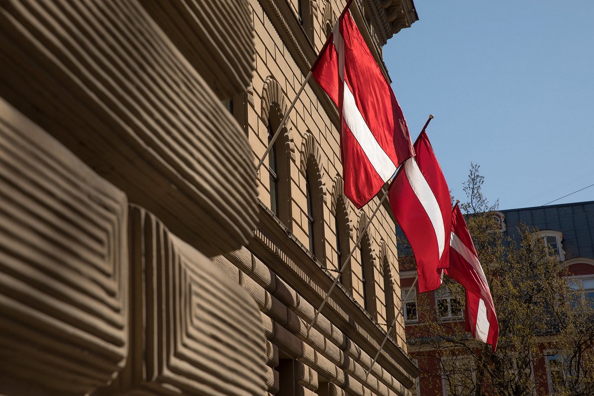 Valsts karogi pie Saeimas ēkas Vecrīgā. Attēls ilustratīvs.