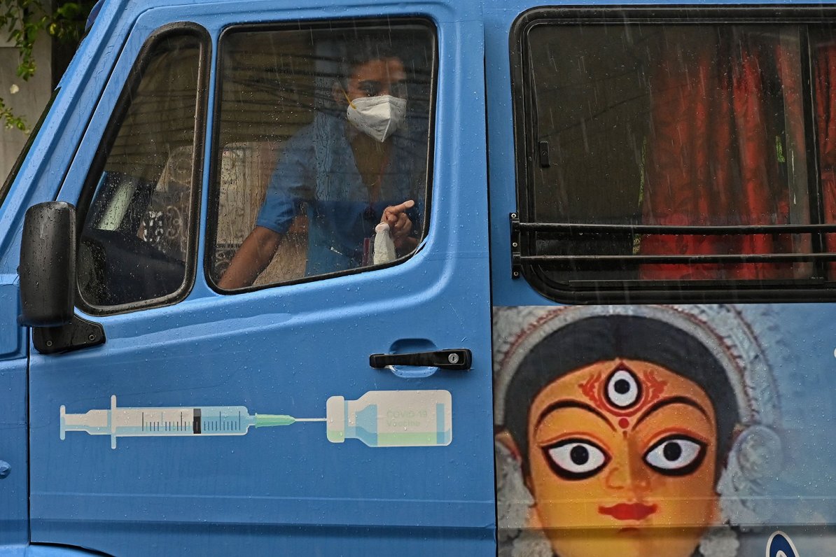 Medicīnas jomas darbinieks Indijā ierodas uz mobilo vakcinēšanu. 2021. gada jūnijs.