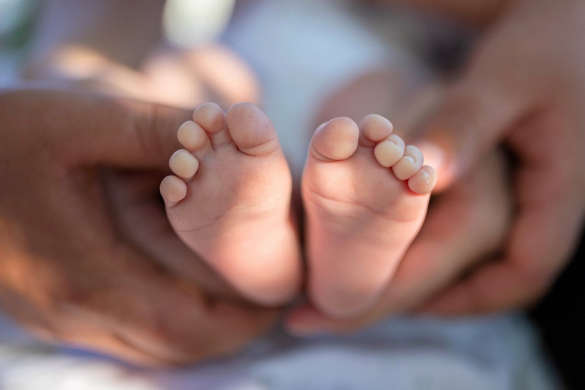 Jaundzimuša mazuļa pēdas vecāku rokās. Attēls ilustratīvs.