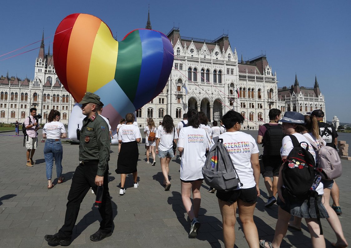 Jaunieši ar varavīksnes karoga krāsas sirdi pie parlamenta ēkas Budapeštā 8. jūlijā, dienā, kad stāj...